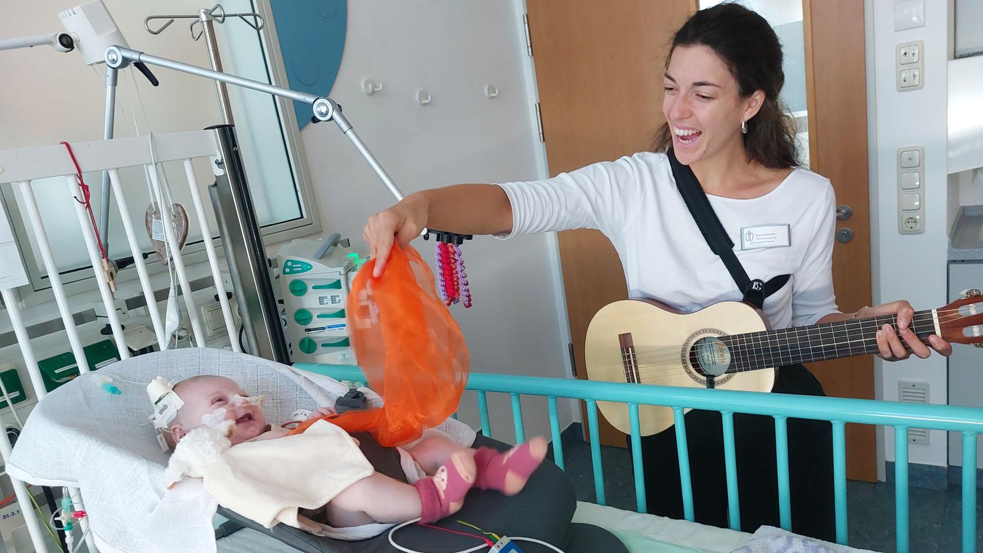 Kinderherzen Musiktherapie,Baby mit Musiktherapeutin im Krankenhaus