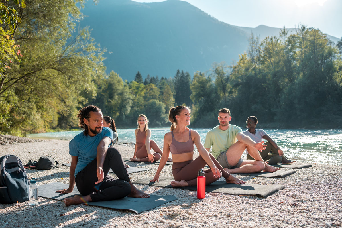 Yogagruppe im Freien am Flussufer
